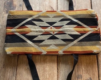 May include: A black and brown geometric patterned tote bag with black straps.