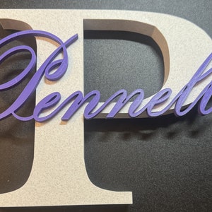 May include: A white wooden letter "P" with the name "Pennell" in purple cursive lettering.