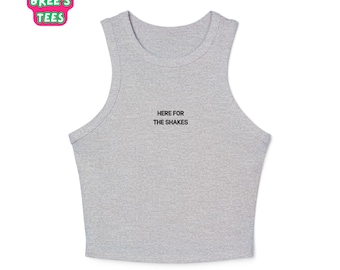 Puede incluir: Camiseta sin mangas gris claro con el texto negro "HERE FOR THE SHAKES". La camiseta sin mangas tiene cuello redondo y es sin mangas. El logotipo de la marca "BREE'S TEES" está en una burbuja rosa y verde.
