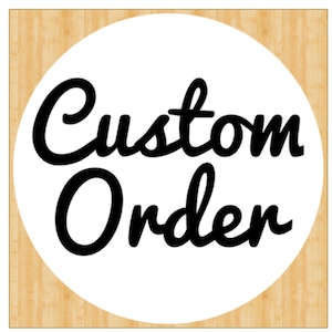 Peut inclure: Un cercle blanc avec un fond noir sur un fond en bois. Le texte "Custom Order" est écrit en cursive noire.