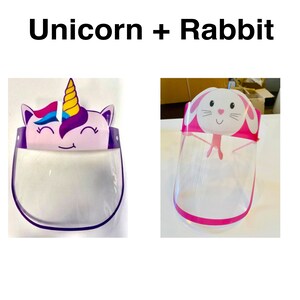 May include: Two clear plastic face shields with colorful cartoon designs. One shield features a pink unicorn with a purple horn and blue mane. The other shield features a pink rabbit with white ears and a pink nose. Both shields have pink trim.