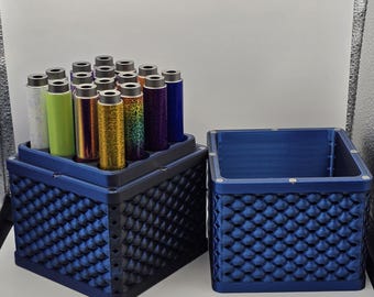 May include: A blue storage container with a textured, scale-like pattern. It holds several cylindrical items in various colors, including white, green, gold, and purple. Another empty container of the same design sits beside it.