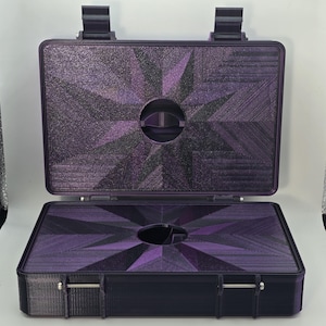 Pu&ograve; includere: Valigetta viola aperta con un design geometrico a forma di stella sulla parte superiore e inferiore. La valigetta ha una maniglia e due chiusure. L'interno ha un ritaglio circolare. La valigetta &egrave; realizzata in un materiale strutturato.