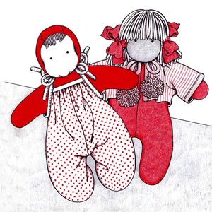 May include: Two handmade fabric dolls. One doll is wearing a red and white polka dot dress and a red bonnet. The other doll is wearing a striped shirt and a pink bow. Both dolls have white yarn hair.