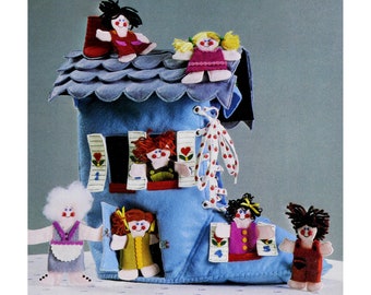 May include: A blue felt boot house with a felt roof and felt dolls. The dolls have yarn hair and are wearing felt clothing. The boot has a white lace-up closure with red polka dots. The house has a window with a felt number 1 and a door with a felt number 3. The boot has a window with a felt number 4 and a door with a felt number 5.