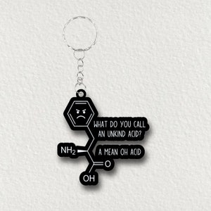 May include: Black keychain with a molecular structure design and the text "WHAT DO YOU CALL AN UNKIND ACID? A MEAN OH ACID". The keychain has a silver metal ring and chain.