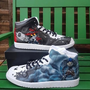 Może przedstawiać: Dwa spersonalizowane buty sportowe o wysokiej cholewce. Jeden but ma czarno-biały wzór z postacią z anime "Trigun" trzymającą broń. Drugi but ma niebiesko-biały wzór z postacią z anime "Death Note" o długich czarnych włosach.