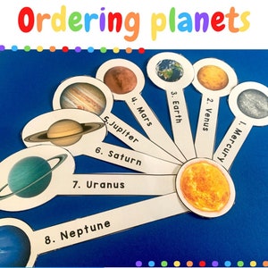 May include: A colourful educational toy for learning about the planets in our solar system.  The planets are depicted on white circles with their names and numbers.  The planets are arranged in order from the sun, starting with Mercury and ending with Neptune.