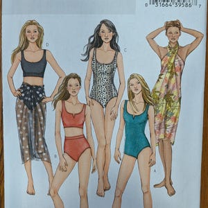 May include: Butterick sewing pattern B4526 for swimwear and cover-ups. The envelope features illustrations of four different outfits including a black crop top with a polka dot sarong, a red two-piece bikini, a leopard print one-piece, and a teal one-piece.