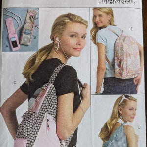 May include: A sewing pattern for a pink and black backpack with a daisy print. The pattern is called Butterick B5054 and is one size. The pattern includes instructions for making a backpack, a small bag, and a phone case.