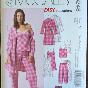 May include: McCall's M5248 sewing pattern for sleepwear. The pattern includes options for a robe, camisole, pants, and shorts. The designs feature a pink plaid and floral print. The size is Y (Xsm-Sml-Med).