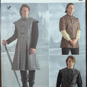 May include: Simplicity Costumes sewing pattern number S9593 for a medieval costume. The pattern includes three different styles: a long tunic with a high collar, a shorter tunic with a high collar, and a vest with a high collar. The pattern is for sizes US 38-44, EU 48-54, and French 48-54.