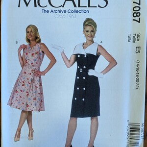 May include: McCall's M7087 The Archive Collection Circa 1963 sewing pattern envelope. Features two dress styles: a sleeveless pink floral wrap dress with a belt and a sleeveless black double-breasted dress with a white collar and white buttons.