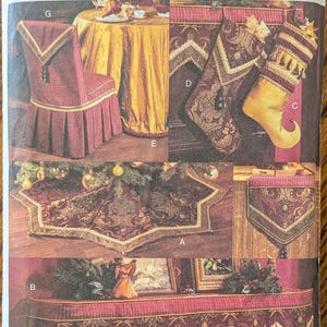 May include: A Vogue Craft sewing pattern envelope 7815 for holiday home decor. The front displays images of a chair cover, stockings, a star-shaped tree skirt, a table runner, and a mantle scarf, all featuring burgundy and gold fabric designs.