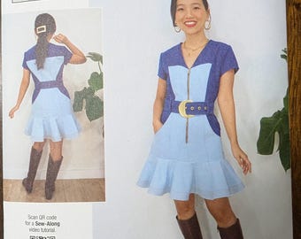 May include: Sewing pattern for a blue and light blue dress with a zipper down the front and a gold belt. The pattern is for sizes 6-8-10-12-14. The pattern includes a QR code for a sew-along video tutorial.
