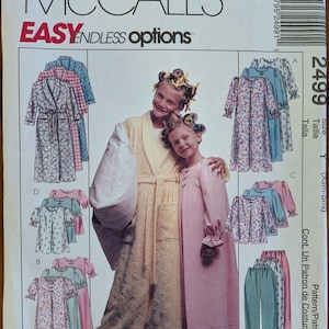 May include: A McCall's 2499 sewing pattern envelope for children's loungewear. The front features illustrations of various robe, nightgown, and pajama styles, alongside a photograph of two children wearing a yellow robe and a pink nightgown.