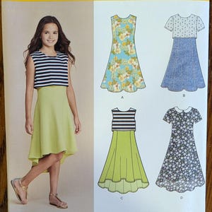 May include: Simplicity sewing pattern 8065 for sizes 8-16. The envelope features illustrations of four dress variations, including sleeveless and short-sleeved styles with floral, striped, and solid patterns, plus a high-low hemline design.