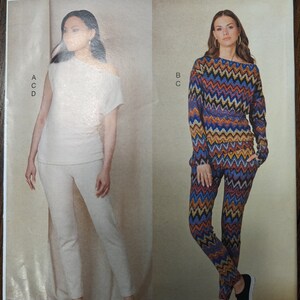 May include: Vogue Patterns sewing pattern for a top and pants. The top is a white off-the-shoulder style with short sleeves. The pants are a chevron print in shades of blue, orange, and yellow. The pattern is for sizes XS-S-M-L-XL-XXL.