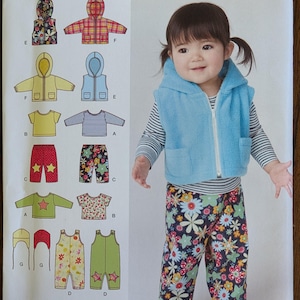 May include: A Simplicity 1566 sewing pattern envelope featuring illustrations of various children's clothing items including hooded vests, long-sleeve shirts, and pants. A photograph shows a child wearing a light blue fleece vest and floral pants.