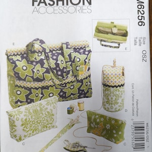 May include: A sewing pattern for a tote bag, a cosmetic bag, a pencil case, and a small pouch. The pattern is printed on white paper with a green and black floral design. The pattern number is M6256 and the size is OSZ.