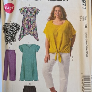 May include: Sewing pattern for a women's top and pants. The pattern includes four different styles: a leopard print top, a purple floral print top, a teal top, and a pair of purple pants. The pattern is for sizes 26W-28W-30W-32W. The pattern is called McCall's M6971.