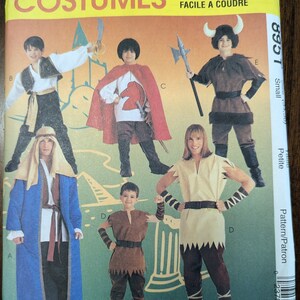 May include: A sewing pattern for five children's costumes. The pattern includes a knight, a shepherd, a viking, a warrior, and a medieval peasant. The pattern is for sizes small and petite.