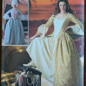 May include: Simplicity pattern 4092 HH featuring a woman in a historical gown. The pattern includes a full-length dress with long sleeves and a fitted bodice. The package also shows a smaller image of a similar dress. Size U.S. 6-12.