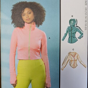May include: A sewing pattern for a zip-up jacket with a hood. The pattern includes three different views: a pink jacket with a green zipper, a teal jacket with a hood, and a beige jacket with a hood. The pattern is for sizes D5 (12-14-16-18-20). The pattern is designed and printed in the USA.