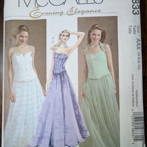 May include: McCall's Evening Elegance sewing pattern for a dress with three different skirt styles. The pattern is for sizes 4-6-8-10. The pattern is shown on three mannequins wearing the different skirt styles. The skirt styles are a white skirt with lace trim, a lavender skirt, and a green skirt.