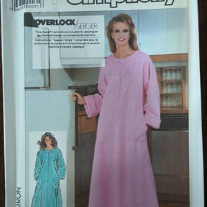 May include: Simplicity sewing pattern 7815 for a long, pink robe with a zipper closure. The pattern includes instructions for Overlock/Serger machines. The package shows a woman wearing the robe and a smaller image of a teal robe.