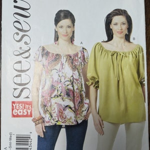 May include: A sewing pattern for a blouse with two different styles. The first style is a printed blouse with short sleeves and a gathered neckline. The second style is a solid green blouse with 3/4 sleeves and a gathered neckline. The pattern is labeled "B5480" and "see & sew".