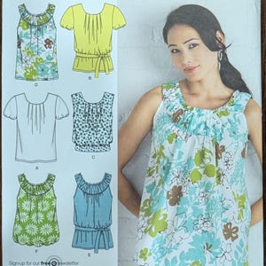 May include: A sewing pattern for six different tops, with a model wearing one of the tops. The pattern is for sizes 6, 8, 10, 12, and 14. The pattern is from Simplicity and is called "6 made easy".