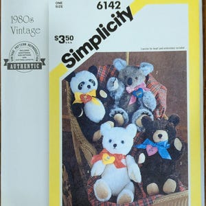 May include: A Simplicity 6142 sewing pattern envelope featuring four plush bears in black and white, grey, white, and dark brown. Each bear wears a colorful ribbon and a heart-shaped patch. The cover includes the text Simplicity 6142 and R11980.