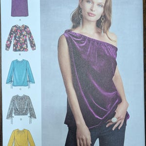 May include: Simplicity sewing pattern 8788. The pattern features a purple velvet one-shoulder top, a skirt, and several blouse designs. The pattern includes sizes U.S. 6-14. The Simplicity logo is at the top right.