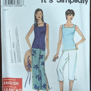 May include: Simplicity sewing pattern featuring two women's outfits. One outfit includes a blue top and floral skirt, the other a striped top and white capri pants. The pattern includes instructions in English, French, and Spanish.