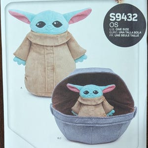 May include: A sewing pattern featuring a plush Grogu and soft space pram. The pattern includes a plush Grogu doll with blue skin, large ears, and a tan robe. The pram is a light blue color. The pattern is labeled "S9432 OS".