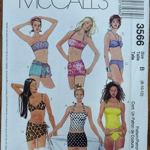 May include: McCall's sewing pattern 3566 for swimwear, featuring illustrations of six different bikini and tankini styles with various floral, polka dot, and animal prints, plus solid colors. Includes size B (8-10-12) and overlock/serger tips.