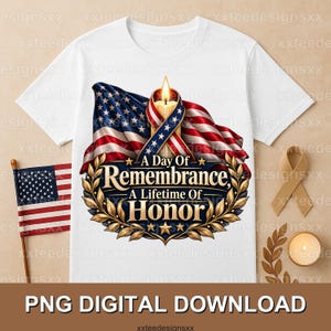 May include: A white t-shirt featuring a graphic of a waving American flag, a lit candle, and a gold laurel wreath. The text reads A Day Of Remembrance A Lifetime Of Honor. A small American flag on a stick and a tan ribbon are visible nearby.