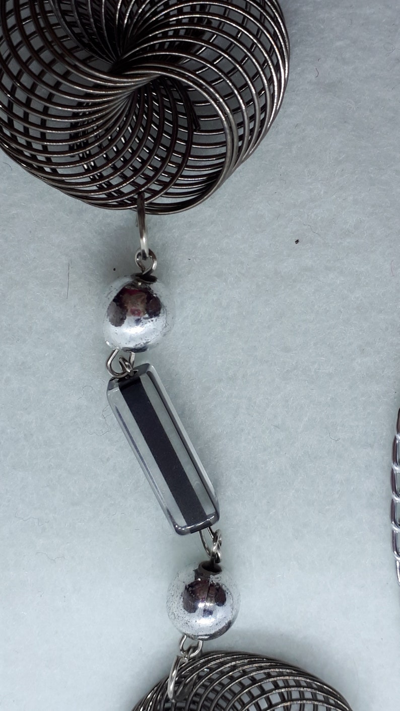 3 twisted wire embellishments. Silvertone chain necklace with silver beads acrylic beads