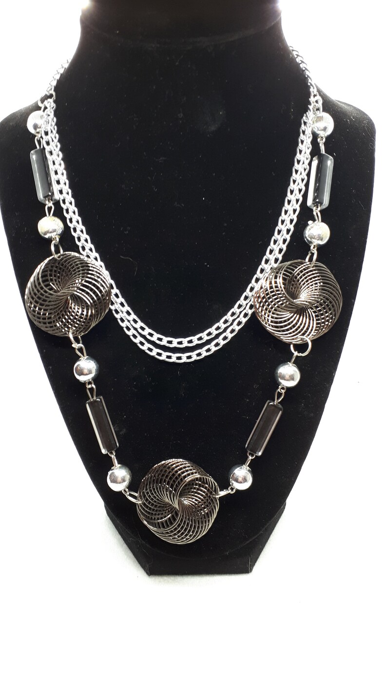 3 twisted wire embellishments. Silvertone chain necklace with silver beads acrylic beads