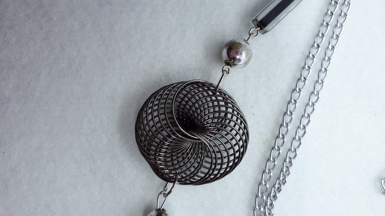 3 twisted wire embellishments. Silvertone chain necklace with silver beads acrylic beads
