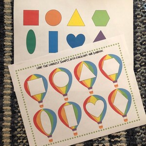 May include: A printable worksheet with a set of colorful shapes and a set of hot air balloons with blank spaces for the shapes. The text "Give the correct shapes into each hot air balloon." is at the top of the page.