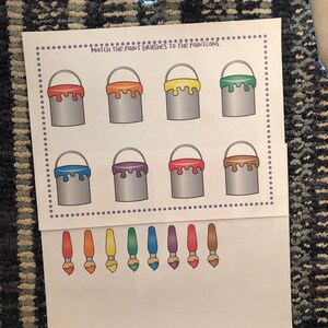 May include: A printable worksheet with the text "Match the paint brushes to the paint cans."  The worksheet has eight paint cans in two rows of four. The paint cans are filled with different colors of paint: orange, yellow, green, purple, red, brown, blue, and light blue.  Below the paint cans are eight paint brushes in a row, each with a different color of paint on the brush: orange, yellow, green, blue, purple, red, brown, and light blue.