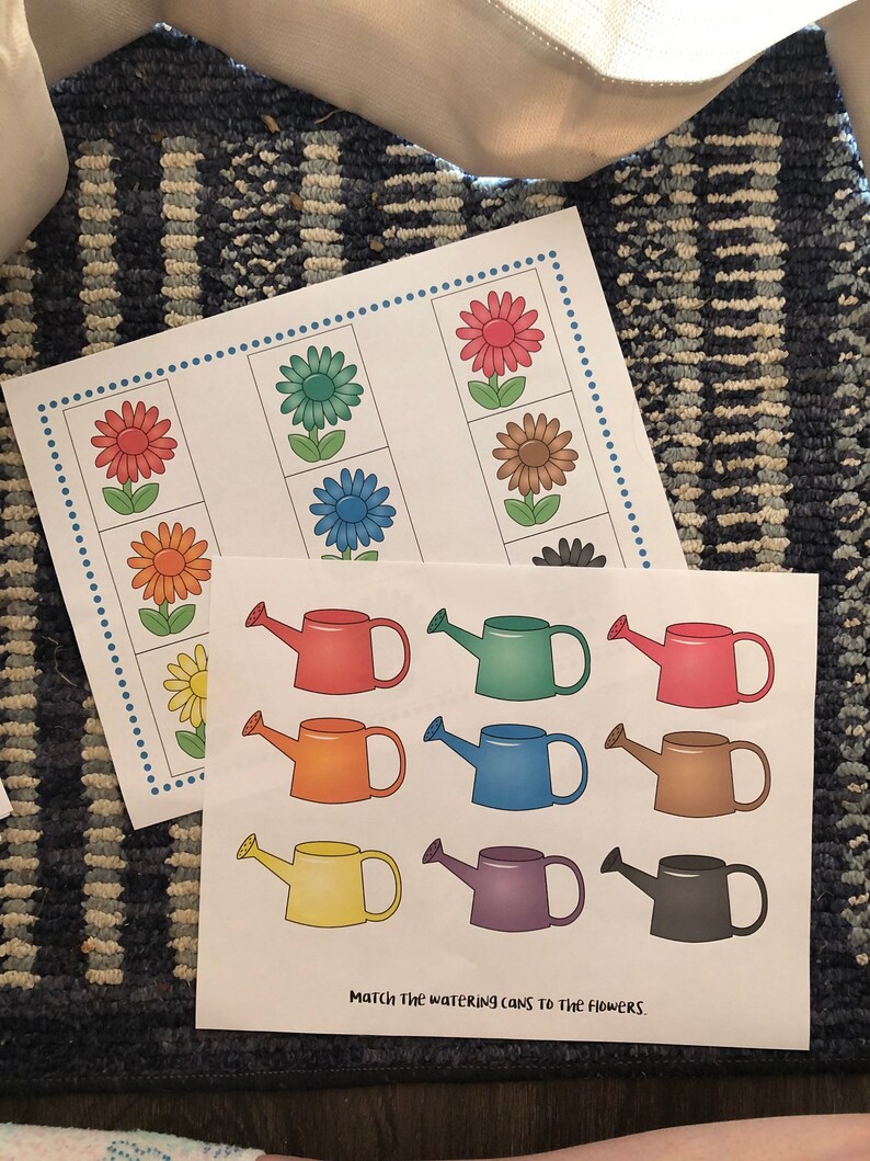 May include: A printable educational activity for kids featuring a matching game with colorful flowers and watering cans. The text "Match the watering cans to the flowers" is printed at the bottom of the page.