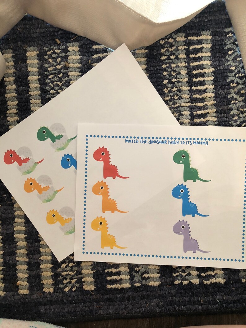 May include: A printable dinosaur matching game with colorful dinosaurs. The game instructs players to "Match the dinosaur baby to its mommy."