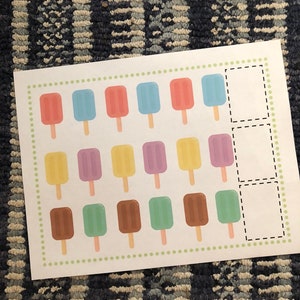 May include: A printable worksheet with a grid of 18 popsicle images in various colors. The popsicles are arranged in three rows of six. There are three blank boxes at the right side of the grid.