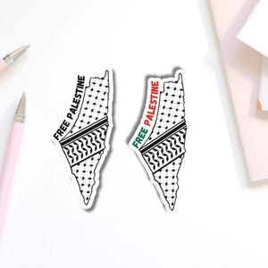 May include: Two stickers in the shape of Palestine, featuring a black and white pattern, a black and white zig-zag pattern, and the text "FREE PALESTINE". One sticker has a green and red stripe, and the other has a black stripe.