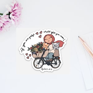 Op de afbeelding: Een sticker met een cartoonillustratie van een vrouw die een rode hoofddoek draagt en fietst met twee katten in een mand. De vrouw glimlacht en de tekst "Als je dankbaar bent, zal ik je meer geven!" staat rond de afbeelding. De tekst "Koran 14:7" staat onder de afbeelding.