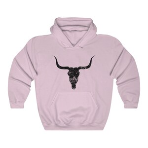 Pu&ograve; includere: Una felpa con cappuccio rosa con una grafica di teschio di toro nero invecchiato.
