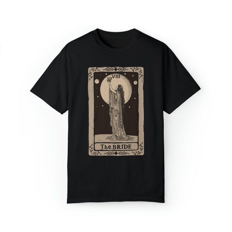 Op de afbeelding: Zwart T-shirt met een vintage tarotkaartontwerp met een vrouw die een kelk vasthoudt. De kaart is gelabeld "VIII The BRIDE".